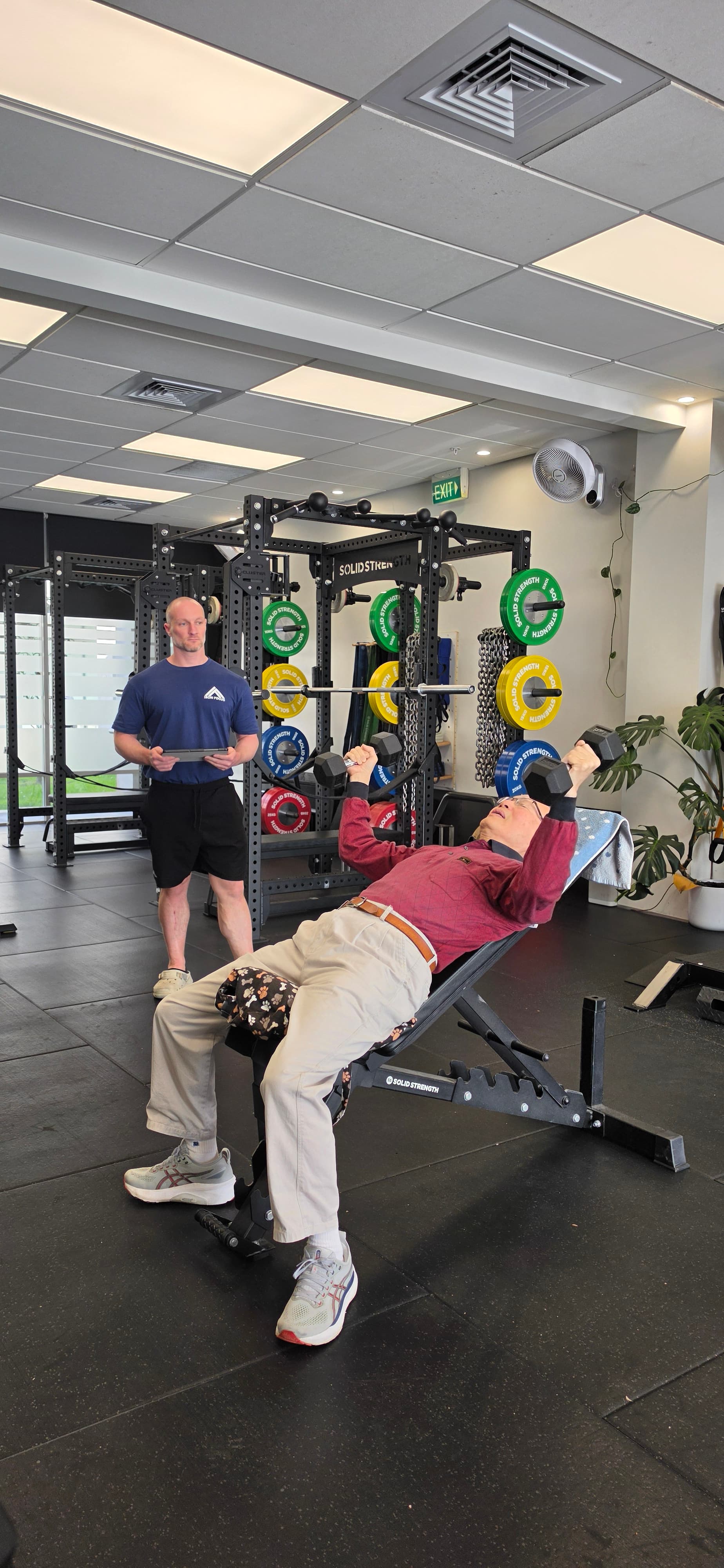 Personal training with a client on incline dumbbell press at Iron Focus